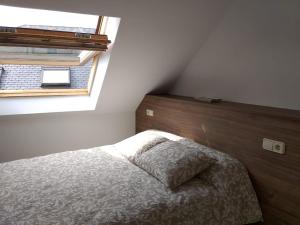 1 dormitorio con 1 cama con cabecero de madera y ventana en ÁTICO EN RIBEIRA(centro) en Ribeira