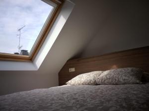 a bedroom with a bed with a large window at Ático centro Ribeira by Cristian&Tamara "alquileres" in Ribeira