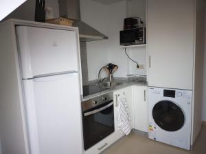 cocina con nevera, fregadero y lavadora en ÁTICO EN RIBEIRA(centro) en Ribeira