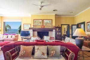 a living room with a red couch and a fireplace at Alterhome Private Villa Cortijo Sierra y Lago in Arcos de la Frontera