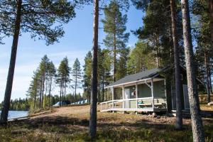 a cabin in the woods next to a lake at Ranua Resort Camping Ranuanjärvi in Ranua