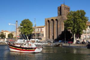 ein Boot im Wasser vor einem Gebäude in der Unterkunft 60m2, 2 chambres proche Hérault & plages in Agde