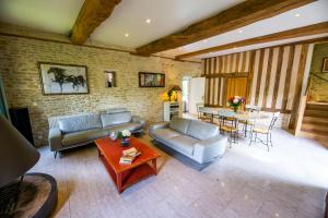a living room with a couch and a table at La Ferme de L'Oudon & SPA in Berville