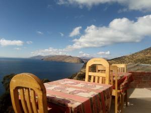 - une table et des chaises avec vue sur l'eau dans l'établissement Las Cabañas Lodge, à Isla de Sol