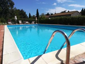 a large blue swimming pool with a metal hand rail at Residence La Casaccia in Venturina Terme