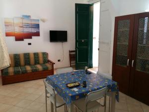 a living room with a table with chairs and a couch at Appartamento Larghetto Licastro in Pizzo