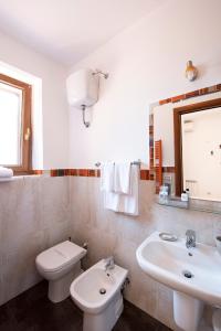 biała łazienka z toaletą i umywalką w obiekcie La Suite di San Pietro w Rzymie