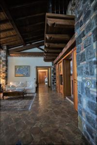 a living room with a couch and a stone wall at Resort Villa Domus Petra in Zagarolo