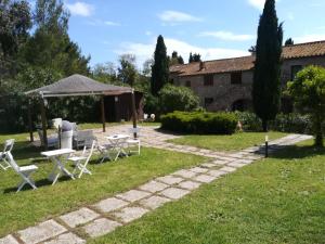 einen Garten mit Tischen und Stühlen vor einem Gebäude in der Unterkunft Residence La Casaccia in Venturina Terme