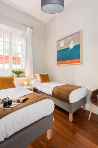 una camera con due letti e un dipinto sul muro di Imperial Luxury & Modern Apartment a Siviglia