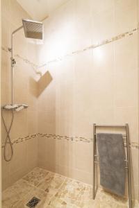 La salle de bains est pourvue d'une douche et d'un fauteuil gris. dans l'établissement Gîte Rilly-la-Montagne, à Rilly-la-Montagne
