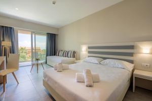 a hotel room with a large bed with towels on it at CNic Gemini Hotel in Mesongi