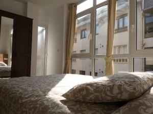 um quarto com uma cama e uma grande janela em Apartamento en Ribeira(centro) 3* planta em Ribeira