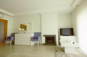 a living room with a fireplace and a tv at Vilamoura Condominio do Pinhal in Vilamoura