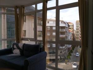 uma sala de estar com um sofá e uma grande janela em Apartamento en Ribeira(centro) 3* planta em Ribeira