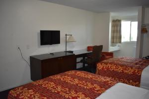 a hotel room with two beds and a desk at Valley Hotel in Rosemead