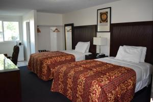 a hotel room with two beds and a window at Valley Hotel in Rosemead
