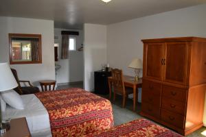 a hotel room with a bed and a cabinet and a table at Valley Hotel in Rosemead