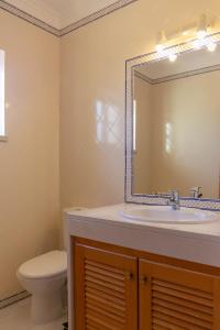 ein Badezimmer mit Waschbecken, Toilette und Spiegel in der Unterkunft Apartment - Golf & Beach Resort in Casal da Lagoa Seca