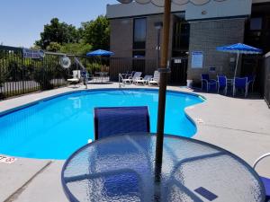 a large swimming pool with chairs and umbrellas at Days Inn by Wyndham Easley West Of Greenville/Clemson Area in Easley