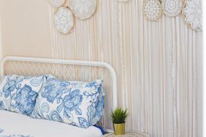 a bedroom with a bed with a blue and white pillow at Sunshine Suite Boutique - Only 5 Min Walk To The Beach in Eilat