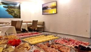 un buffet de différents types de nourriture sur une table dans l'établissement Hotel Garni Seerösl am Wörthersee , Kärnten, à Krumpendorf am Wörthersee