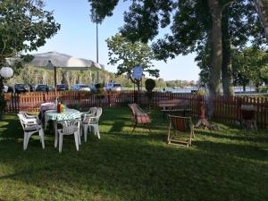 a table and chairs in a yard with a fence at Ośrodek Wczasowy Daga in Dziwnów