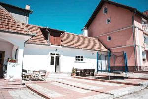 a building with tables and chairs in front of it at Pensiunea Ana in Baile Felix