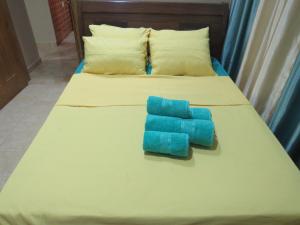 a bed with two blue pillows on it at Apartments Ocean Breez RedSeaLine Hurghada in Hurghada