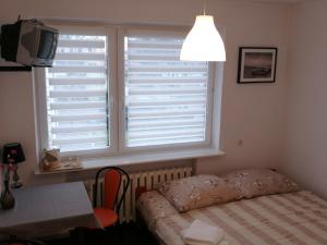 a bedroom with a window and a bed and a table at Ośrodek Wczasowy Daga in Dziwnów