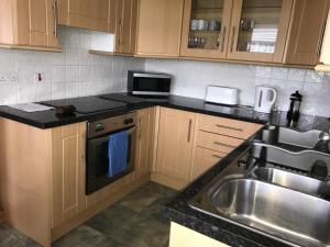 a kitchen with a sink and a counter top at Ayrshire cottage in Kilmarnock