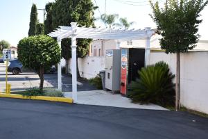 a white pergola with a gas pump on a street at Valley Hotel in Rosemead