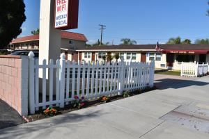 a white picket fence in front of a restaurant at Valley Hotel in Rosemead