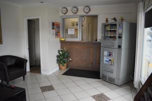 a kitchen with a refrigerator and a counter at Valley Hotel in Rosemead