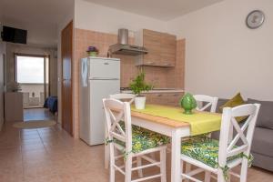 a kitchen with a table with chairs and a refrigerator at Al Faro Guest House in Vieste
