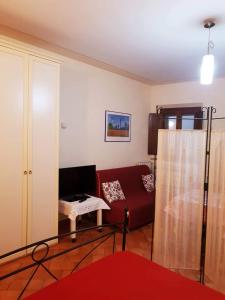 ein Wohnzimmer mit einem roten Sofa und einem Tisch in der Unterkunft La Piccola Toscana 2 in Peccioli