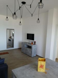 a living room with a television and a table at Appartamento fronte mare in Porto Recanati