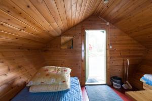 a room with a bed in a wooden room at Ranua Resort Camping Ranuanjärvi in Ranua