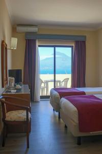 a hotel room with two beds and a view of the ocean at Hotel Horta in Horta