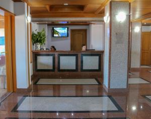 a lobby with a bar with two people in it at Hotel Horta in Horta +18 photos