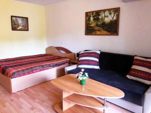 a room with a couch and a bed and a table at Butai labai geroje vietoje prie juros in Palanga