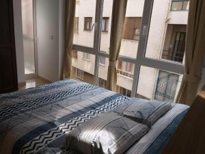 Un dormitorio con una cama y una ventana grande. en Apartamento en Ribeira(centro) 2* planta, en Ribeira
