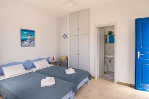 a bedroom with two beds and a bathroom at Evgenia Rooms and Apartments in Chora Folegandros