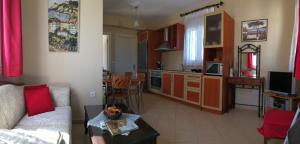 a living room with a white couch and a kitchen at ilyda Residence apts in Skala Kallonis