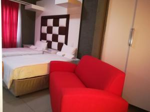 a bedroom with a bed and a red couch at Jericho Hotel and Conferences in Thohoyandou