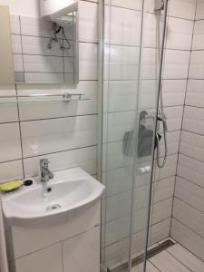 a white bathroom with a sink and a shower at Teraszos ház in Balatonlelle +11 photos
