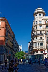 a group of people walking on a city street with buildings at Arenal Suites Preciados in Madrid