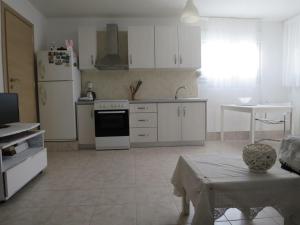 a kitchen with white appliances and a table in it at Guesthouse with Garden in Komotini