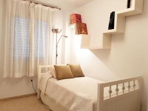 Apartamento turístico en Sevilla في إشبيلية: غرفة نوم بسرير ونافذة