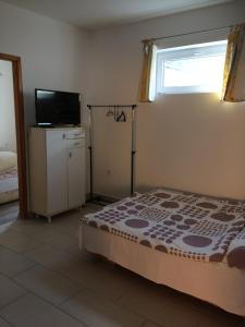 a bedroom with a bed and a television and a window at Teraszos ház in Balatonlelle
